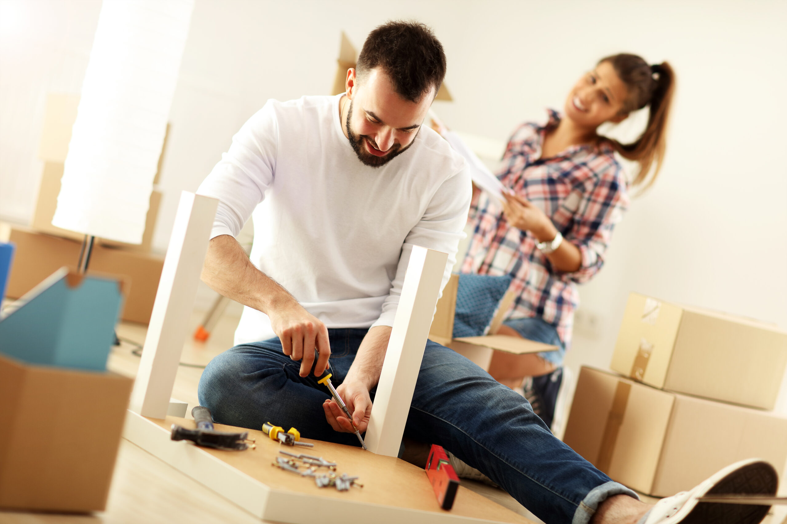 pareja feliz montando muebles